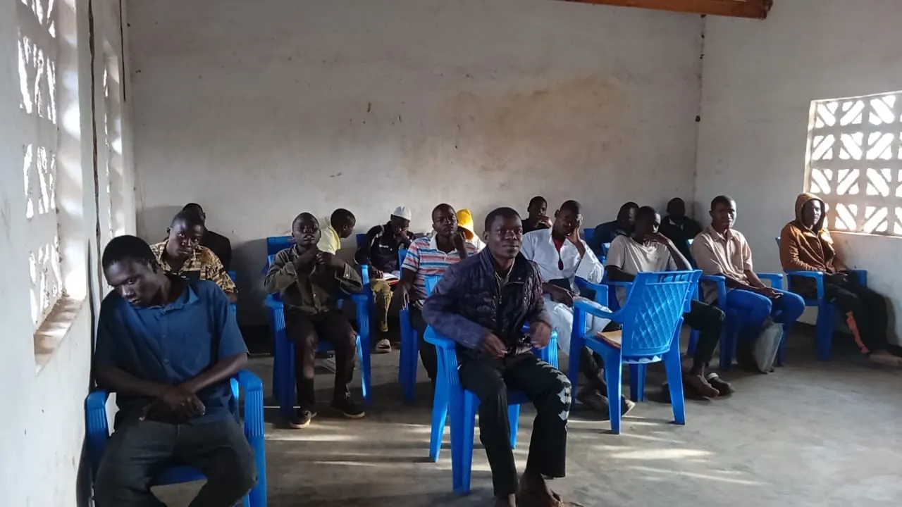 Young men seated for a lecture in a rural classroom.
